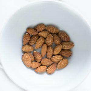 keto snacks brown almond nuts on white ceramic bowl